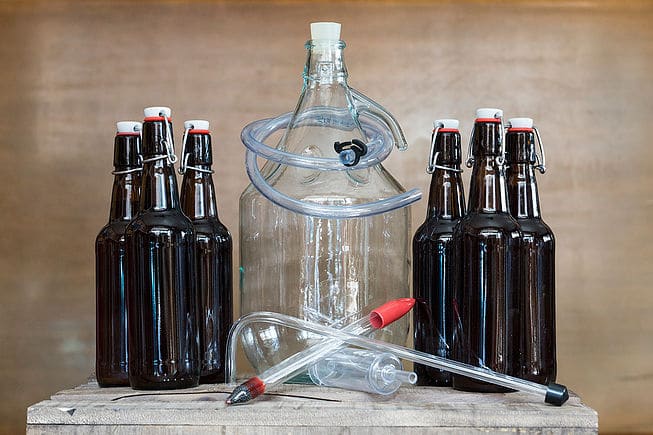 Bonbonne et bouteilles de bière fournies dans le kit de fabrication The Blgian Brewery