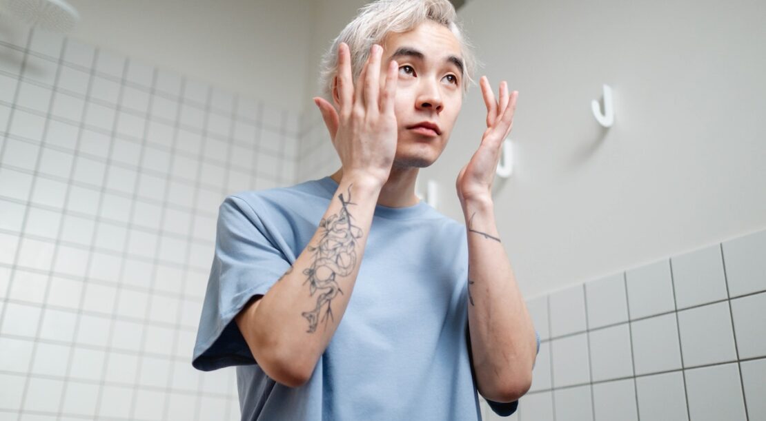 Homme qui applique un sérum à acide hyaluronique